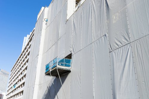 Installation de bâche sur échafaudage pour protection bâtiment
